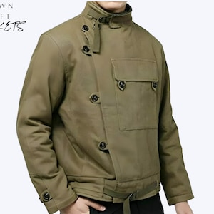 May include: Olive green jacket with a high collar, multiple black buttons, and a front pocket. The jacket has a belt at the waist and the text "CROWN CRAFT JACKETS" in the upper left corner. The jacket is made of a durable material.