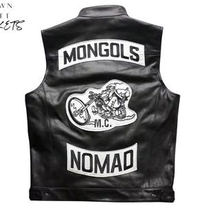 Puede incluir: Chaleco de cuero negro con parches blancos. El chaleco presenta el texto "MONGOLS" en la parte superior, un gráfico de motocicleta en el centro y "NOMAD" en la parte inferior. El texto "CROWN CRAFT JACKETS" está en la esquina superior izquierda.