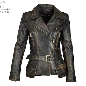 Puede incluir: Chaqueta de cuero marrón desgastado con cuello de solapa, cierre de cremallera asimétrico y cintura con cinturón. La chaqueta tiene múltiples bolsillos y el texto "CROWN CRAFT JACKETS" en la esquina superior izquierda.