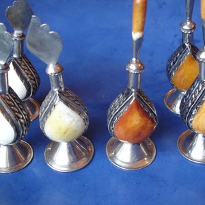 Pode incluir: Conjunto de seis garrafas decorativas com tampas e bases prateadas. As garrafas são feitas de osso e têm um acabamento perolado. Três garrafas são brancas e três são laranja.