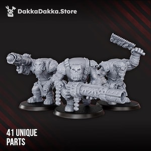 May include: Three gray miniature figures of Orcs, each armed with large weapons, stand on black bases. The figures are detailed with armor and skull-like faces. The text "41 UNIQUE PARTS" is at the bottom, and the DakkaDakka.Store logo is at the top.