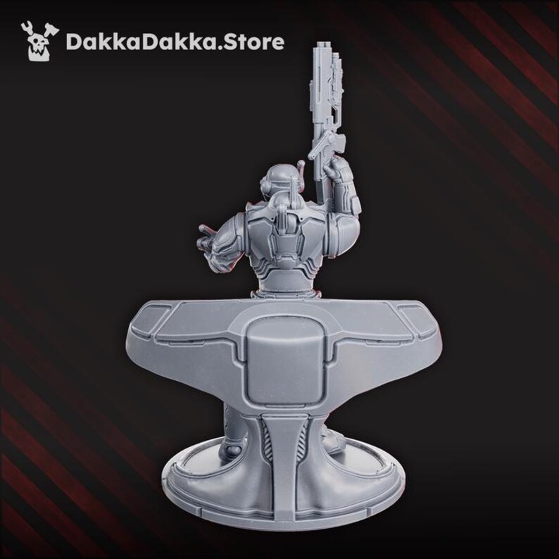 May include: A gray, futuristic figurine of a soldier holding a gun, mounted on a stylized platform. The figurine is detailed with armor plating and mechanical elements. The text "DakkaDakka.Store" is in the upper left corner.
