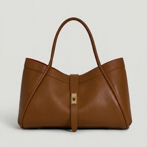 K&ouml;nnte beinhalten: Eine braune Ledertasche mit rotem Innenfutter. Die Tasche hat einen geschwungenen oberen Rand, einen langen Griff und einen Riemenverschluss mit goldfarbener Schnalle. Die Tasche hat eine strukturierte Form.