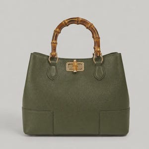 May include: An olive green handbag with a textured surface, featuring a curved bamboo handle and a gold-toned metal turn-lock closure with a bamboo accent. The bag has a structured base and gold hardware connecting the handle to the body.