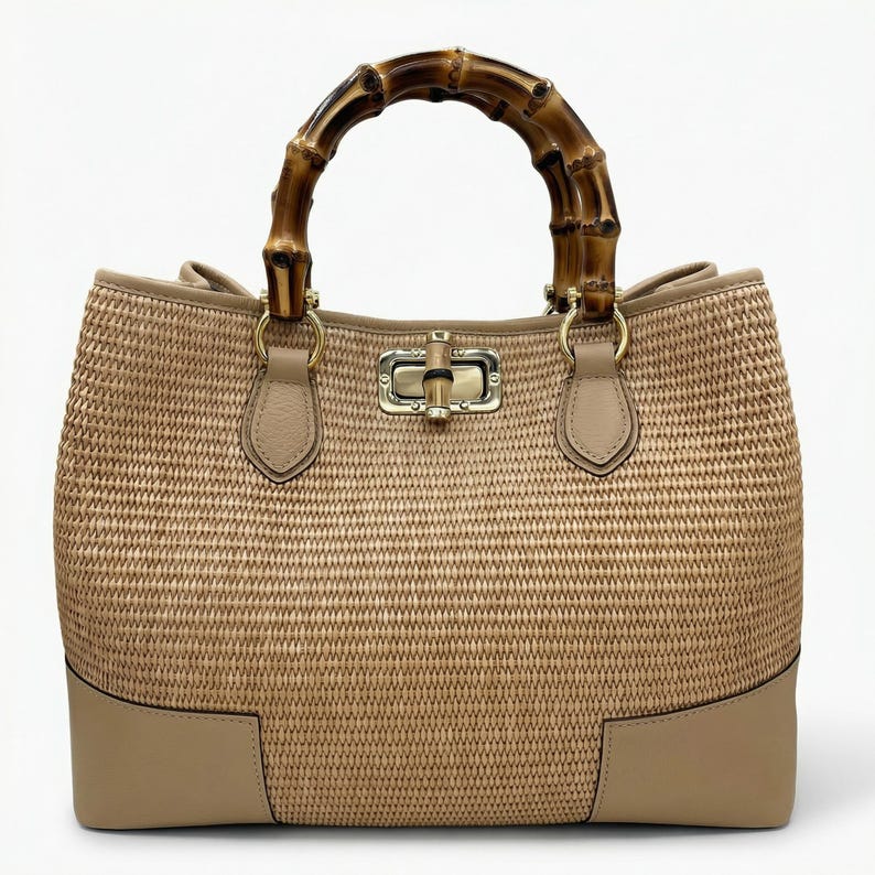 Pode incluir: Uma bolsa bege tecida com uma al&ccedil;a de bambu. A bolsa tem formato retangular com corpo tecido e detalhes em couro na base e nas fixa&ccedil;&otilde;es da al&ccedil;a. A al&ccedil;a &eacute; feita de bambu curvo. Um fecho dourado prende a parte superior.