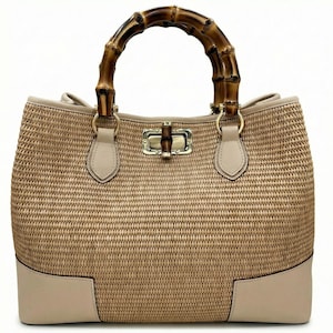 Pode incluir: Bolsa bege com textura tecida, com al&ccedil;a de bambu e fecho dourado. Os cantos inferiores e a borda s&atilde;o de cor bege claro. A bolsa tem um formato estruturado e um design cl&aacute;ssico.