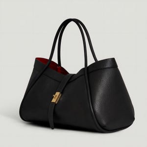 K&ouml;nnte beinhalten: Eine schwarze Ledertasche mit rotem Innenfutter. Die Tasche hat zwei schwarze Griffe und einen goldfarbenen Verschluss. Das Design ist strukturiert und elegant, geeignet f&uuml;r den t&auml;glichen Gebrauch.
