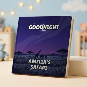 May include: A square hardcover book with a dark purple night sky illustration featuring a crescent moon, stars, and a savanna landscape with silhouettes of a giraffe, elephants, and zebras. The text reads GOODNIGHT AMELIA'S SAFARI.
