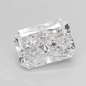 May include: A clear, radiant-cut diamond with a rectangular shape. The gemstone has many facets that reflect light. The diamond is set against a plain, light background.