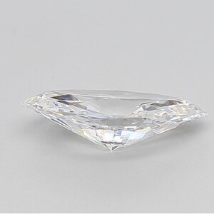 May include: A clear, faceted gemstone with a marquise cut. The diamond is highly reflective, with multiple facets catching the light. The gemstone is set against a plain, light background.