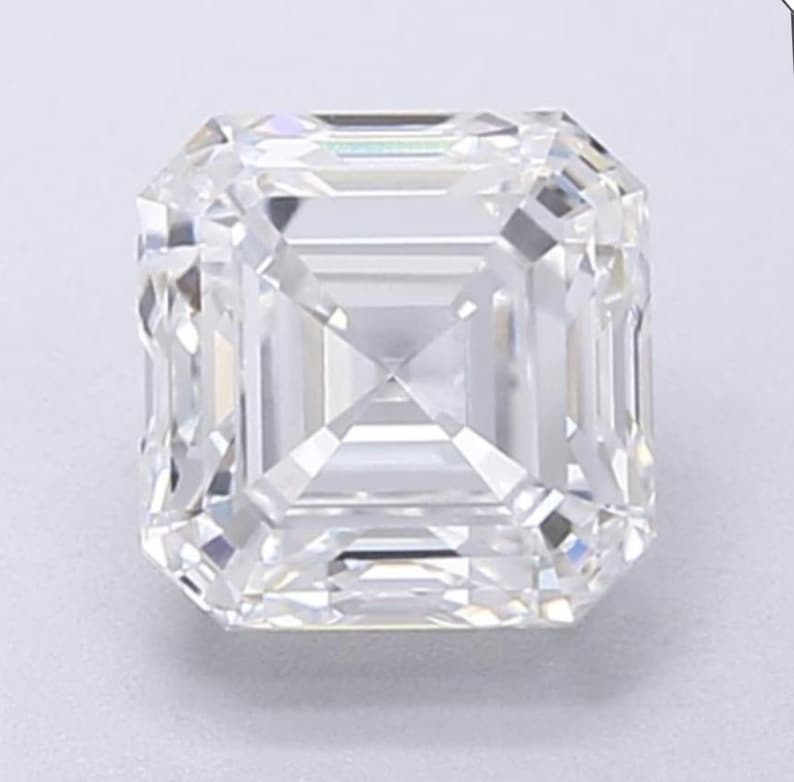 May include: A clear, square-cut diamond with a brilliant, multifaceted design. The gemstone's facets reflect light, creating a sparkling effect. The diamond's shape is a classic, elegant choice for jewelry.