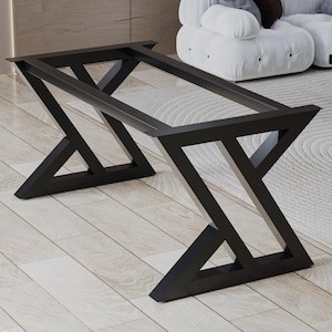 May include: A black metal table base with a geometric design. The base has angled legs forming an X shape, supporting a rectangular frame. The table base is designed for a modern living room.