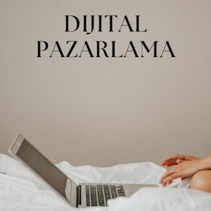 以下が含まれることがあります： 「DİJİTAL PAZARLAMA」というタイトルの電子書籍の表紙。黒いフォントで「E-BOOK」という文字が上にあります。白いベッドの上に開いたノートパソコンがあり、その下に「BİR DİJİTAL HİKAYE」というテキストがあります。背景はニュートラルなベージュです。