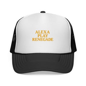 May include: A black and white trucker hat with the text "ALEXA PLAY RENEGADE" in gold lettering. The hat has a white front panel and a black mesh back, with a curved black brim.