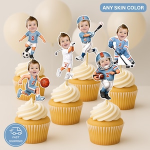 May include: A set of six custom cupcake toppers featuring a child's face on various sports-themed bodies, including soccer, golf, baseball, football, and hockey players, all wearing jerseys with the number 2, displayed on frosted cupcakes.