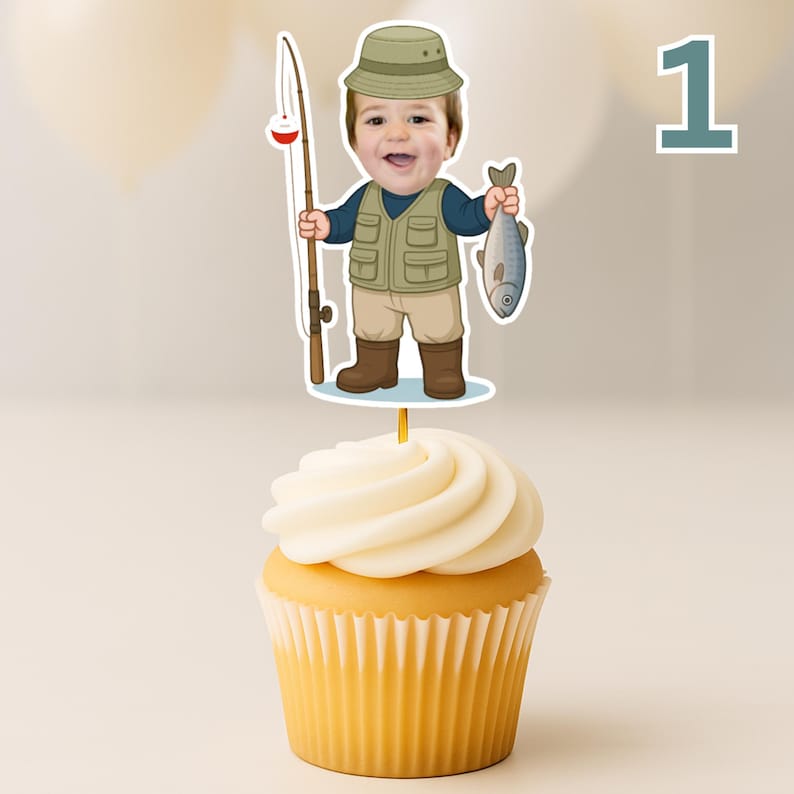 K&ouml;nnte beinhalten: Ein Cupcake mit einem dekorativen Papieraufstecker, der eine Comic-Illustration eines Kindes mit beigem Anglerhut, blauem Langarmshirt, beiger Anglerweste mit Taschen, beiger Hose und braunen Stiefeln zeigt, das eine Angel und einen Fisch h&auml;lt.