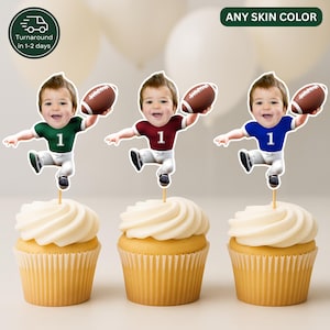 Op de afbeelding: Drie cupcake-toppers met het gezicht van een kind op het lichaam van een cartoon footballspeler in een shirt met het nummer 1. De shirts zijn groen, bordeauxrood en blauw. Elk figuurtje houdt een bruine football vast op een witte cupcake.