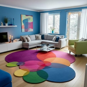 May include: A contemporary living room with a vibrant rug composed of overlapping circles in purple, red, orange, pink, green, yellow, and blue. The room features blue walls, a grey sectional sofa, and a green armchair.