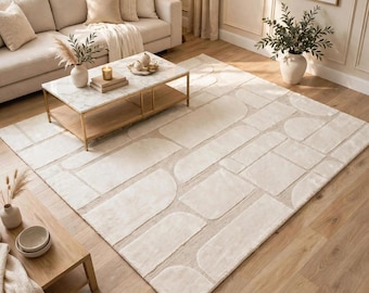 Pode incluir: Um tapete retangular grande com um padrão geométrico de cor creme, apresentando retângulos e semicírculos em relevo de textura macia sobre um fundo de tecido plano. O design cria um aspeto subtil e em camadas em toda a superfície.