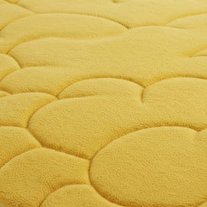 Puede incluir: Primer plano de una alfombra de ba&ntilde;o amarilla texturizada con un dise&ntilde;o similar a guijarros. La alfombra tiene un aspecto suave y afelpado y un color uniforme. El dise&ntilde;o presenta formas redondeadas e interconectadas.