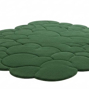 Puede incluir: Una alfombra verde con forma de nube y superficie texturizada. La alfombra est&aacute; formada por m&uacute;ltiples formas redondeadas interconectadas, creando un dise&ntilde;o &uacute;nico y org&aacute;nico. El color es un verde intenso, y la alfombra est&aacute; sobre un fondo blanco.