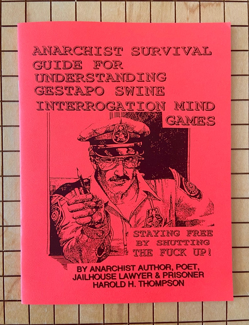 May include: A pink pamphlet with black text titled "Anarchist Survival Guide for Understanding Gestapo Swine Interrogation Mind Games". The cover features a black and white illustration of a police officer pointing a finger at the viewer with the text "Staying Free by Shutting the Fuck Up!" and "By Anarchist Author, Poet, Jailhouse Lawyer & Prisoner Harold H. Thompson".
