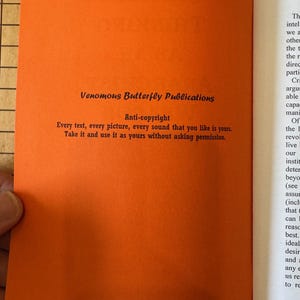 May include: A close-up of a bright orange page with black text. The text reads "Venomous Butterfly Publications" and "Anti-copyright" with a statement about using the content without permission.