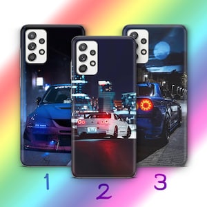 Könnte beinhalten: Drei Handyhüllen mit Autodesigns. Die Hüllen zeigen Bilder von Autos bei Nacht mit Stadtkulissen. Die Autos sind in Blau- und Weißtönen gehalten. Die Hüllen sind mit 1, 2 und 3 nummeriert.