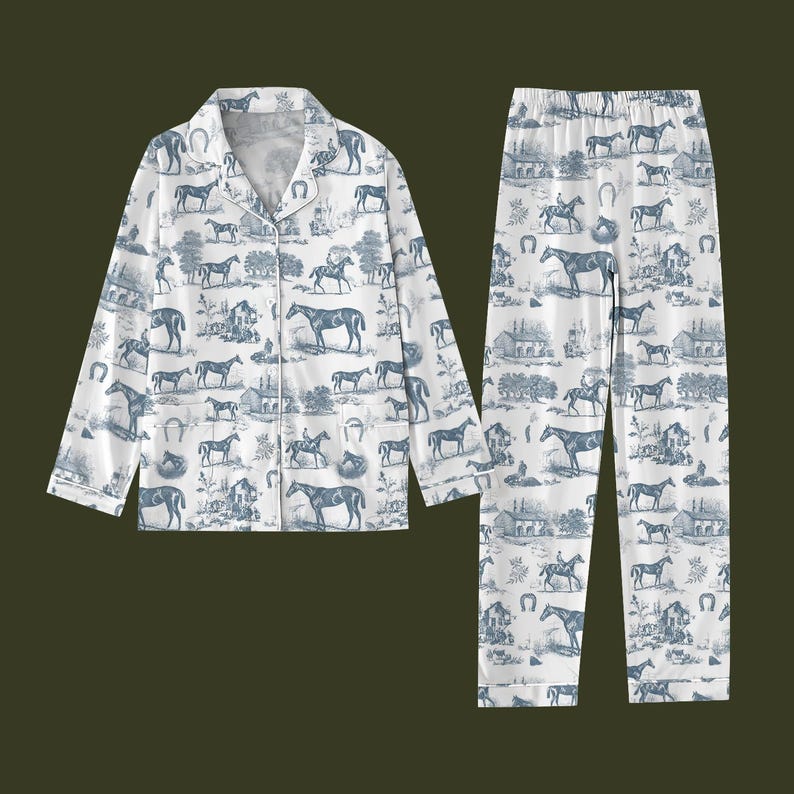 K&ouml;nnte beinhalten: Wei&szlig;es Pyjama-Set mit blauem Pferde- und Hufeisenmuster. Das Set besteht aus einem Hemd mit Kn&ouml;pfen und einer passenden Hose. Das Design zeigt Pferde, Reiter und l&auml;ndliche Szenen. Der Pyjama ist aus einem weichen, leichten Stoff gefertigt.