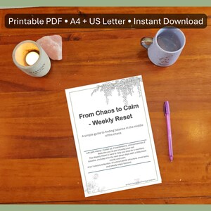 Peut inclure: Une table en bois présente un PDF imprimable intitulé « From Chaos to Calm - Weekly Reset » avec un stylo, une bougie allumée, un cristal rose et une tasse. Le texte sur le PDF propose un guide pour trouver l'équilibre. La bougie est dans un petit support blanc.