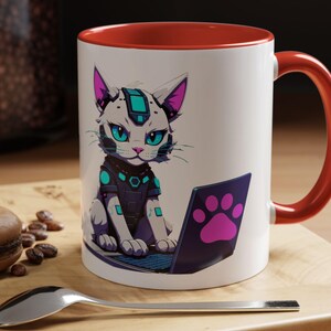 Pode incluir: Caneca de cerâmica branca com interior e alça vermelhos. A caneca apresenta um gato de desenho animado com um design futurista, sentado em frente a um laptop com uma pegada na tela. O gato tem olhos turquesa e um design turquesa e roxo.