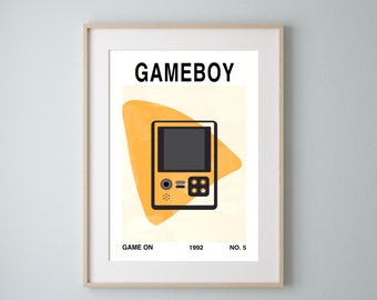 May include: Framed art print featuring a yellow Gameboy illustration with a black screen and buttons. The word "GAMEBOY" is at the top, with "GAME ON 1992 NO. 5" at the bottom. The background has an abstract yellow shape.