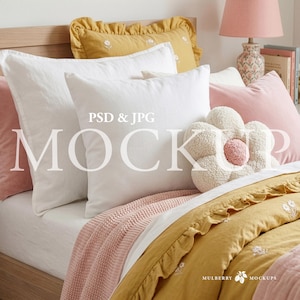 May include: A bed with white, pink, and yellow bedding. The bed has white pillows, a pink pillow, and a flower-shaped pillow. The bedding includes a pink knitted throw and a yellow comforter with a ruffled edge. The text "PSD & JPG MOCKUP" is visible.