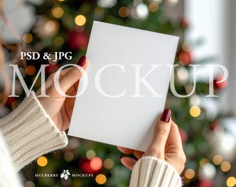 May include: A blank white rectangular card held in two hands. The card is oriented vertically with a smooth, matte surface. The text PSD & JPG MOCKUP is printed in white on the card, and the text MULBERRY MOCKUPS is printed at the bottom.
