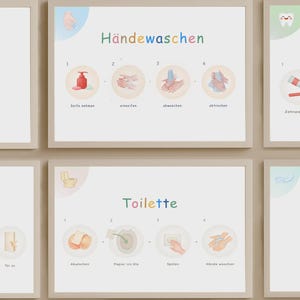 Könnte beinhalten: Eine Reihe von gerahmten Lehrplakaten mit Aquarellillustrationen. Ein Poster zeigt die Schritte zum Händewaschen mit dem deutschen Text "Händewaschen". Ein weiteres Poster zeigt die Toilettenhygiene mit dem französischen Text "Toilette".