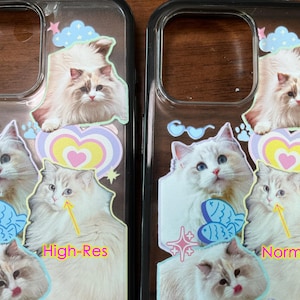 Op de afbeelding: Twee doorzichtige telefoonhoesjes met kattenontwerpen. Elke hoes heeft meerdere kattenillustraties, een hart, vissen en sterrenafbeeldingen. Eén hoesje is gemarkeerd met "High-Res" en de andere met "Normal". De katten zijn wit en bruin.