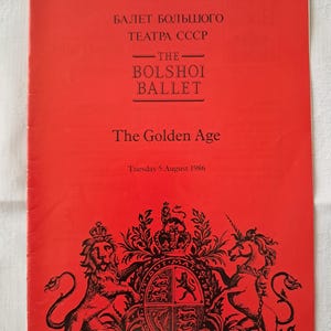 Può includere: Una copertina di programma rossa per la Royal Opera House con testo in inglese e cirillico. La copertina pubblicizza "The Bolshoi Ballet" che presenta "The Golden Age" martedì 5 agosto 1986. Il fondo presenta uno stemma.