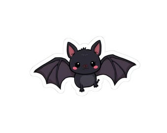 May include: A sticker featuring a cartoon bat with a cute design. The bat is black with dark purple wings and pink cheeks and ears. The bat is in a flying pose with its wings spread.