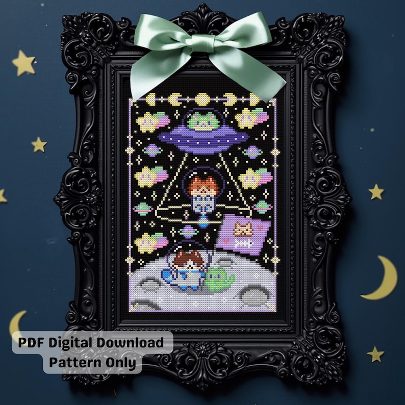 May include: Cross-stitch art in a black frame with a light green bow. The artwork depicts an alien-themed scene with a UFO, astronauts, and a cat. The text "PDF Digital Download Pattern Only" is at the bottom.