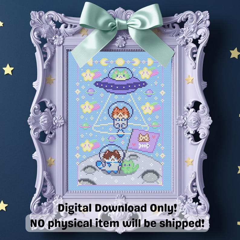 May include: A framed cross-stitch design featuring a space-themed illustration with cartoon cats in spacesuits and a UFO. The design is in a light blue color scheme with stars and planets. The frame is lavender with a green bow.