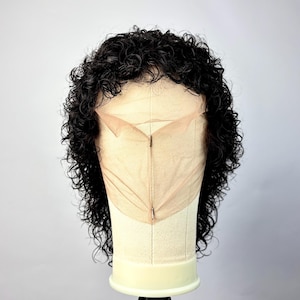Op de afbeelding: Een zwarte krullende pruik op een mannequinhoofd. De pruik heeft een kanten voorkant en is gestyled met strakke, gedefinieerde krullen. Het mannequinhoofd is lichtbeige van kleur en de achtergrond is effen wit.