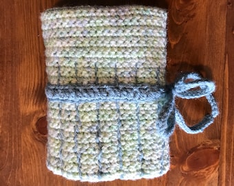 May include: A crocheted light blue and green pouch with a light blue crocheted tie. The pouch is folded and tied with the tie.