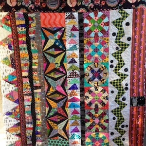 Puede incluir: Una colcha colorida con una variedad de patrones y diseños geométricos. La colcha está hecha de diferentes telas en tonos de rojo, verde, azul, amarillo y negro. La colcha es un mosaico de diferentes formas y tamaños, creando un diseño único y llamativo.