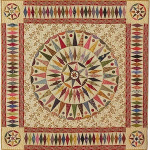 Puede incluir: Una colcha beige con un gran diseño de estrella en explosión de colores en el centro. La explosión de estrellas está compuesta por varios tonos de rojo, verde, azul y amarillo. La colcha está rodeada por un borde de formas de diamante en tonos de rojo, marrón y crema.