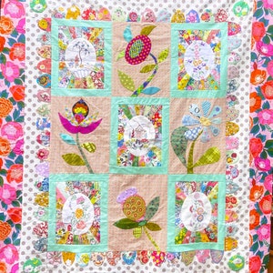 Peut inclure: Une courtepointe en patchwork sur le thème floral. La courtepointe est composée de neuf carrés, chacun avec un motif floral différent. Les carrés sont entourés d'une bordure de pois roses et blancs. La courtepointe est réalisée avec une variété de tissus, notamment des imprimés floraux, des couleurs unies et des motifs géométriques.