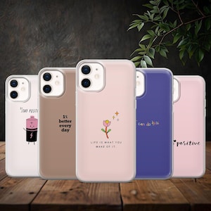 Pode incluir: Uma coleção de cinco capas de telemóvel com citações inspiradoras e gráficos. As capas são de várias cores, incluindo transparente, castanho, rosa e azul. As capas apresentam textos como "Stay Positive", "1% better every day" e "Life is what you make of it".