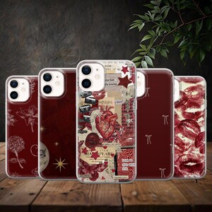 May include: A selection of clear phone cases with diverse designs. The cases showcase graphics such as a floral print, a moon and stars, a collage with a heart and text, and a pattern of red lips. The cases are presented on a wooden surface.
