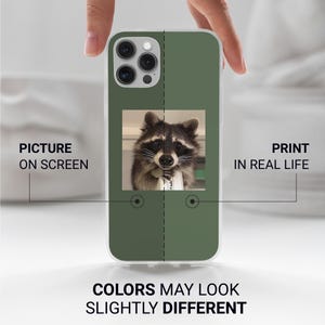 May include: A green phone case featuring a raccoon holding a small object. The case has a clear border and text that reads "PICTURE ON SCREEN" and "PRINT IN REAL LIFE". The text "COLORS MAY LOOK SLIGHTLY DIFFERENT" is also visible.