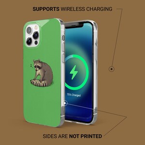 May include: A green phone case featuring a raccoon illustration. The phone screen displays a charging symbol with 75% charged. The text "SUPPORTS WIRELESS CHARGING" and "SIDES ARE NOT PRINTED" are also visible.