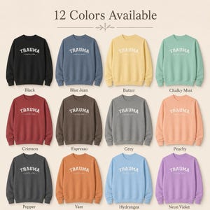 Grid displaying twelve different colored sweatshirts, each with the TRAUMA LEVEL ONE text.